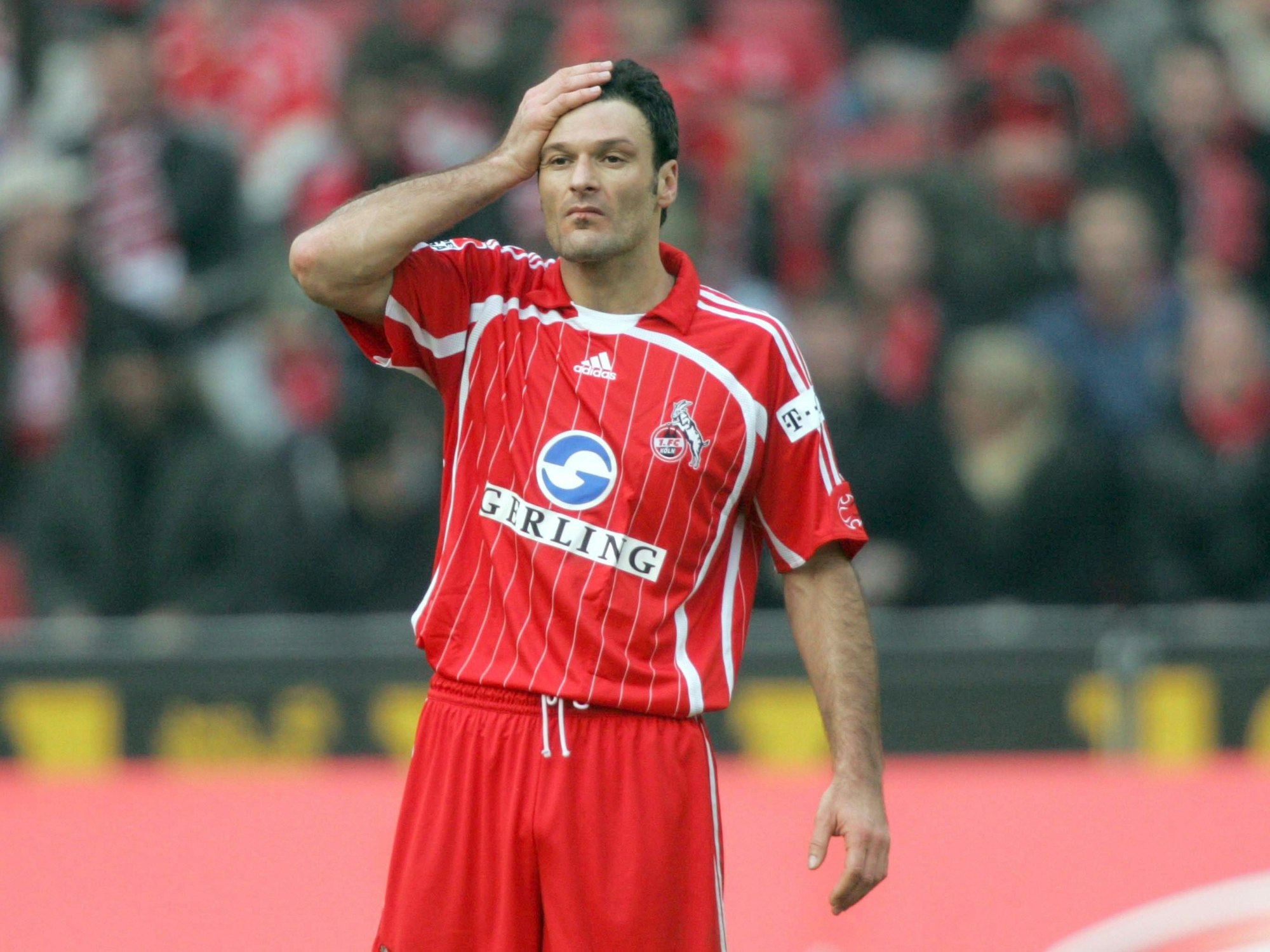 Alpay Özalan steht auf dem Platz und fasst sich an den Kopf.