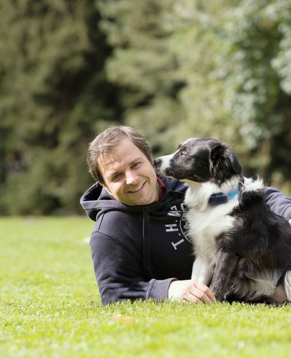 Hundeprofi Martin Rütter liegt mit einem Hund auf einer Wiese. Das Bild wurde am neunten Oktober 2020 aufgenommen.
