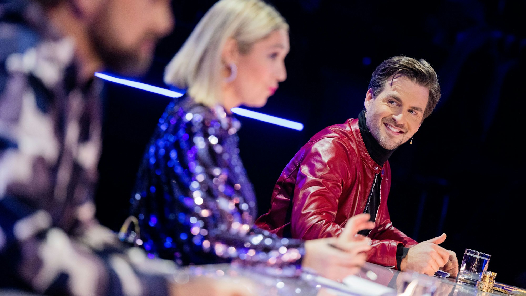 Alexander Klaws (von r.), Ruth Moschner und Steven Gätjen aus dem Rateteam sitzen in der ProSieben-Show „The Masked Dancer“ am Ratepult.