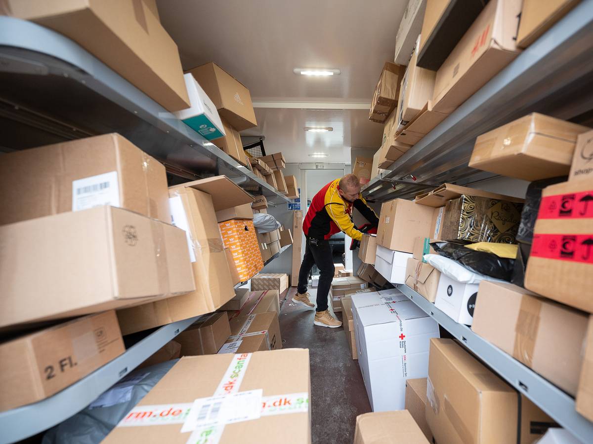 Ein DHL-Mitarbeiter sortiert in seinem Transporter die Pakete und Päckchen für die nächsten Zustellungen. (Zu dpa "Zusteller tragen vor Weihnachten Millionen Päckchen aus")
