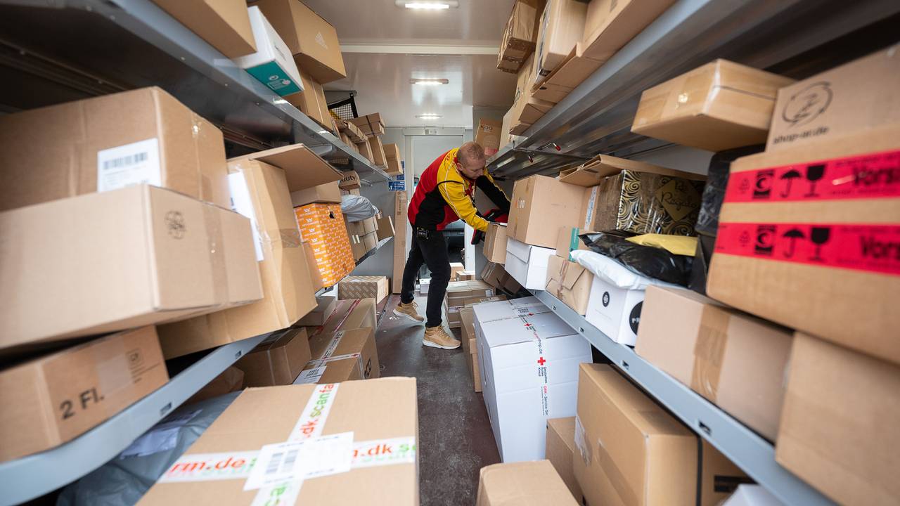 Ein DHL-Mitarbeiter sortiert in seinem Transporter die Pakete und Päckchen für die nächsten Zustellungen. (Zu dpa "Zusteller tragen vor Weihnachten Millionen Päckchen aus")