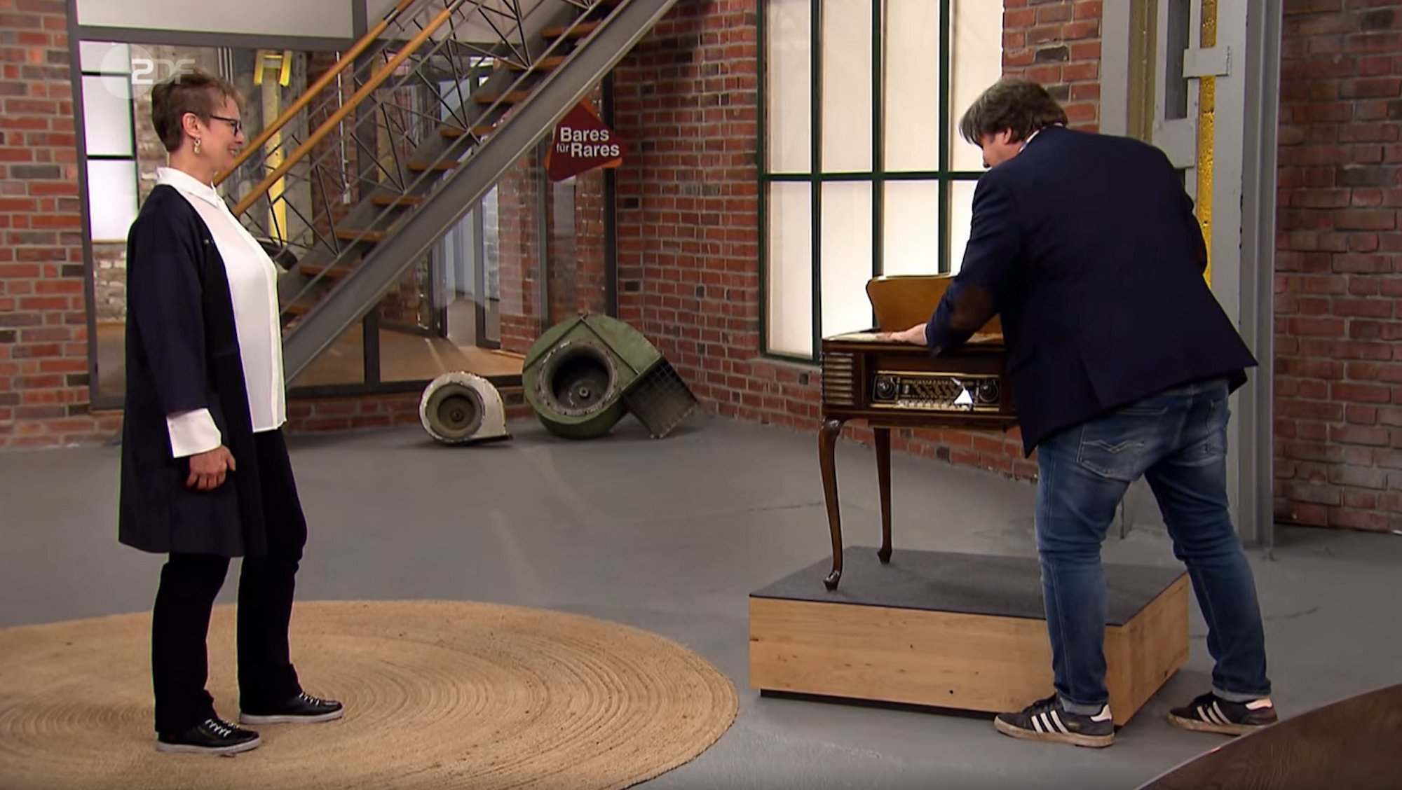 „Bares für Rares“-Händler Daniel Meyer bezahlt das Radio von Verkäuferin Regina Kaleita. Das Bild entstand in der Sendung vom 7. Januar.