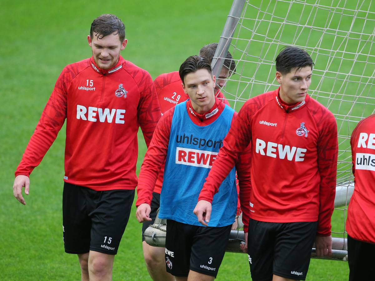 Luca Kilian, Noah Katterbach und Sava Cestic gehen im Training des 1. FC Köln über den Rasen.