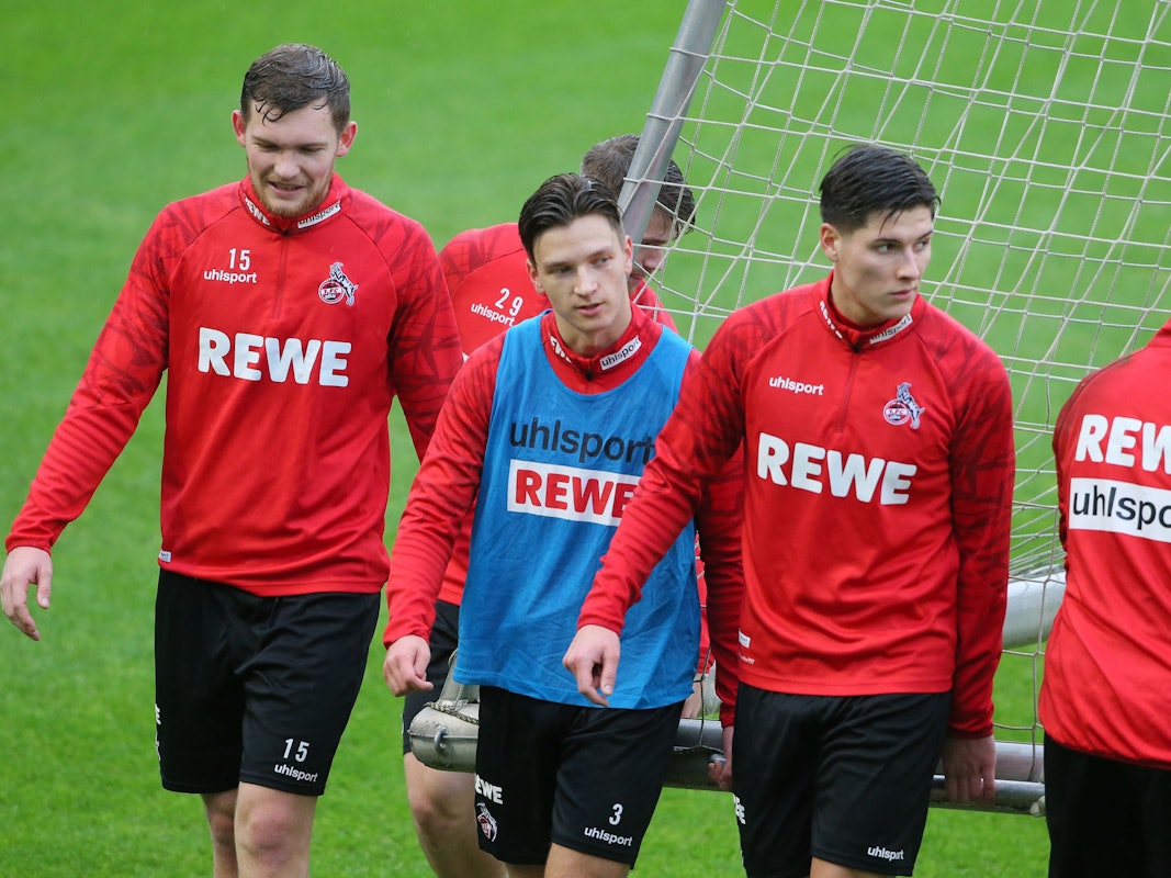 Luca Kilian, Noah Katterbach und Sava Cestic gehen im Training des 1. FC Köln über den Rasen.