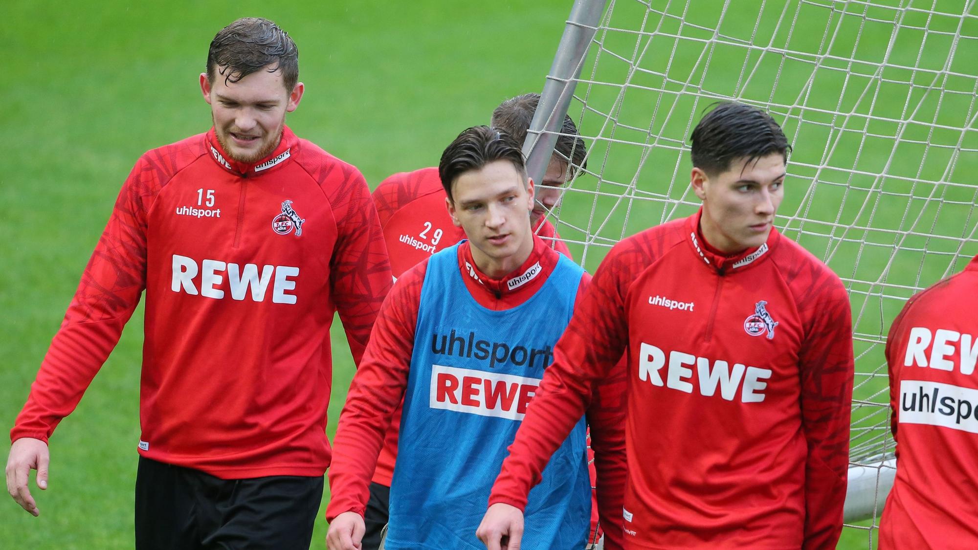 Luca Kilian, Noah Katterbach und Sava Cestic gehen im Training des 1. FC Köln über den Rasen.