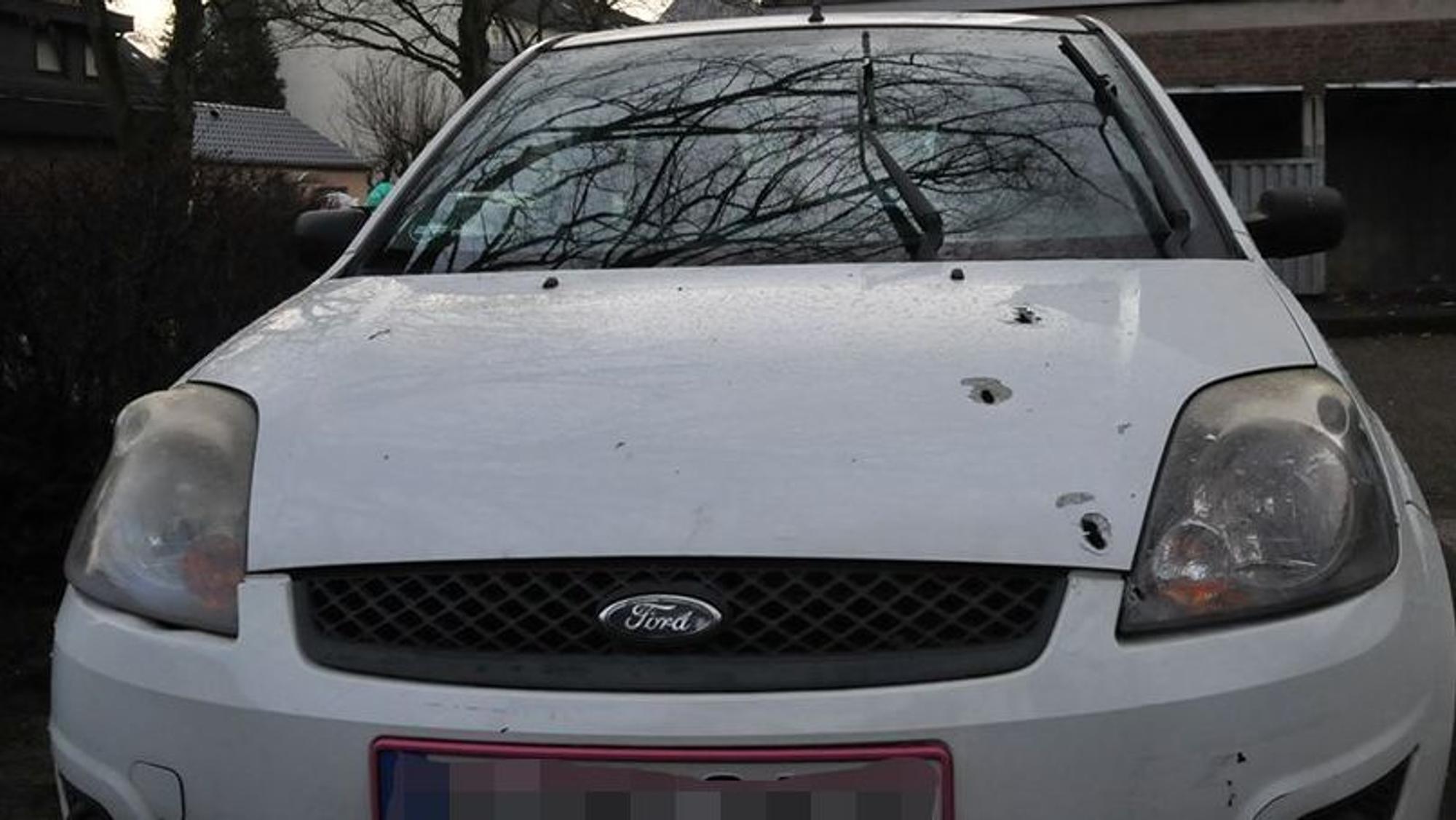 Auf der Motorhaube eines Ford Fiestas sieht man mehrere Einschusslöcher.