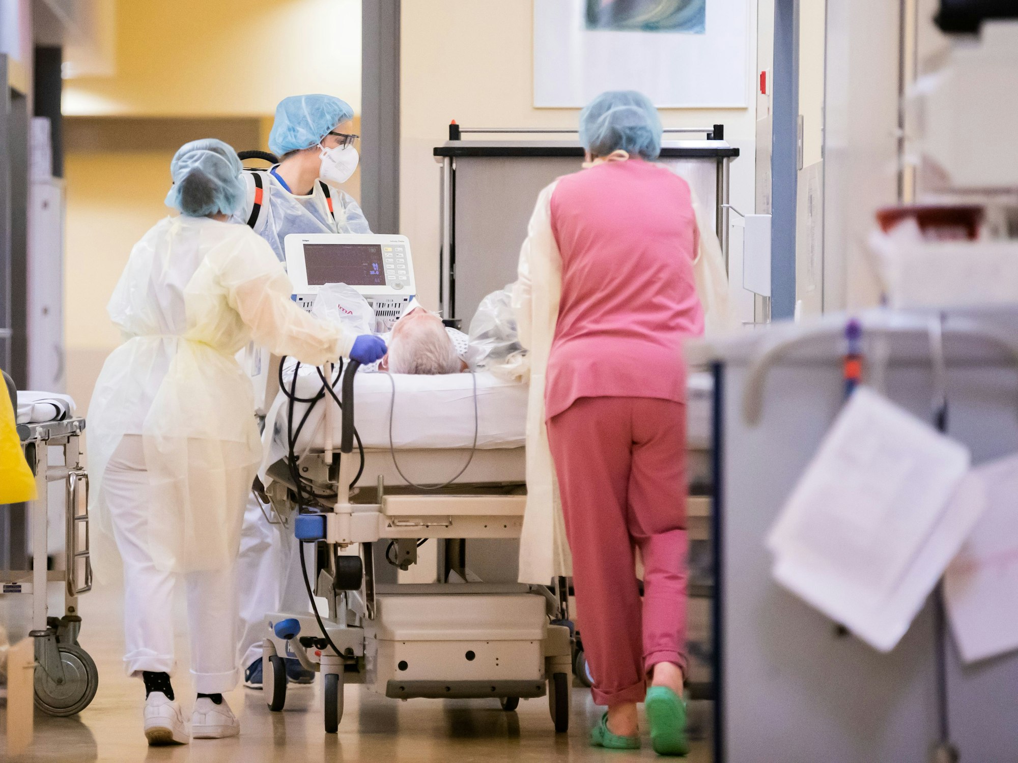 Eine Assistenzärztin (M) schiebt mit Intensivfachpflegerinnen auf der Intensivstation des Gemeinschaftskrankenhauses Havelhöhe das Krankenbett eines Covid-19-Patienten.