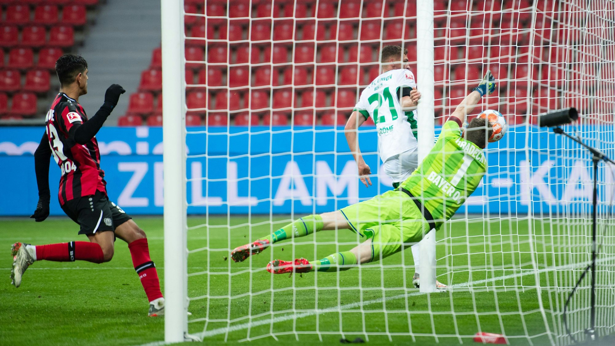 Grischa Prömel von Union Berlin trifft gegen Leverkusens Torhüter Lukas Hradecky.