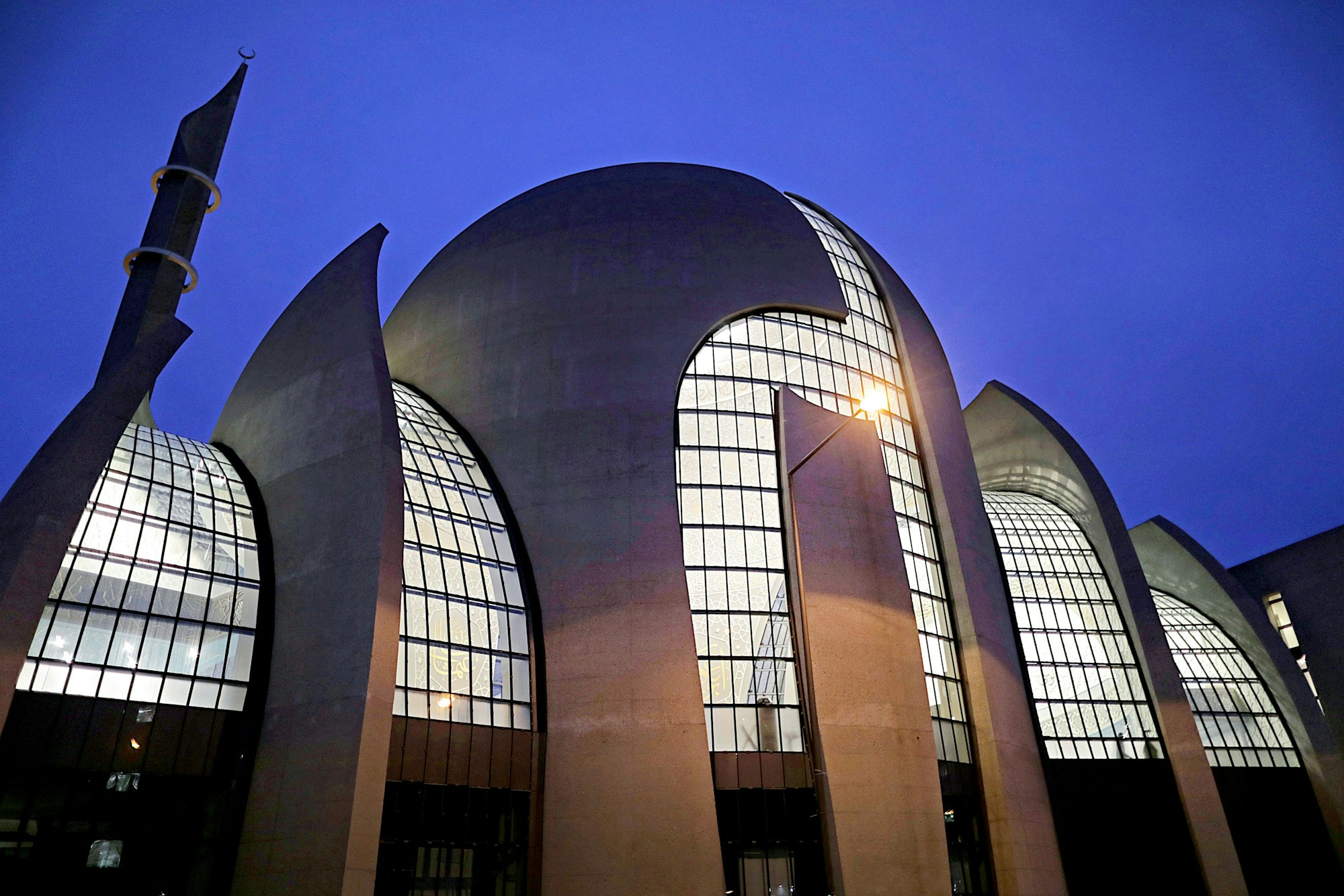 Die Ditib-Zentralmoschee in Köln-Ehrenfeld leuchtet am Abend.