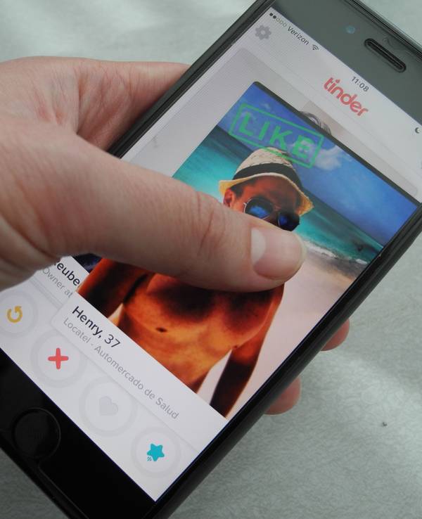 Ein Nutzer hält am 29.03.2016 in New York (USA) ein Smartphone, auf dem die App "Tinder" läuft, in der Hand.