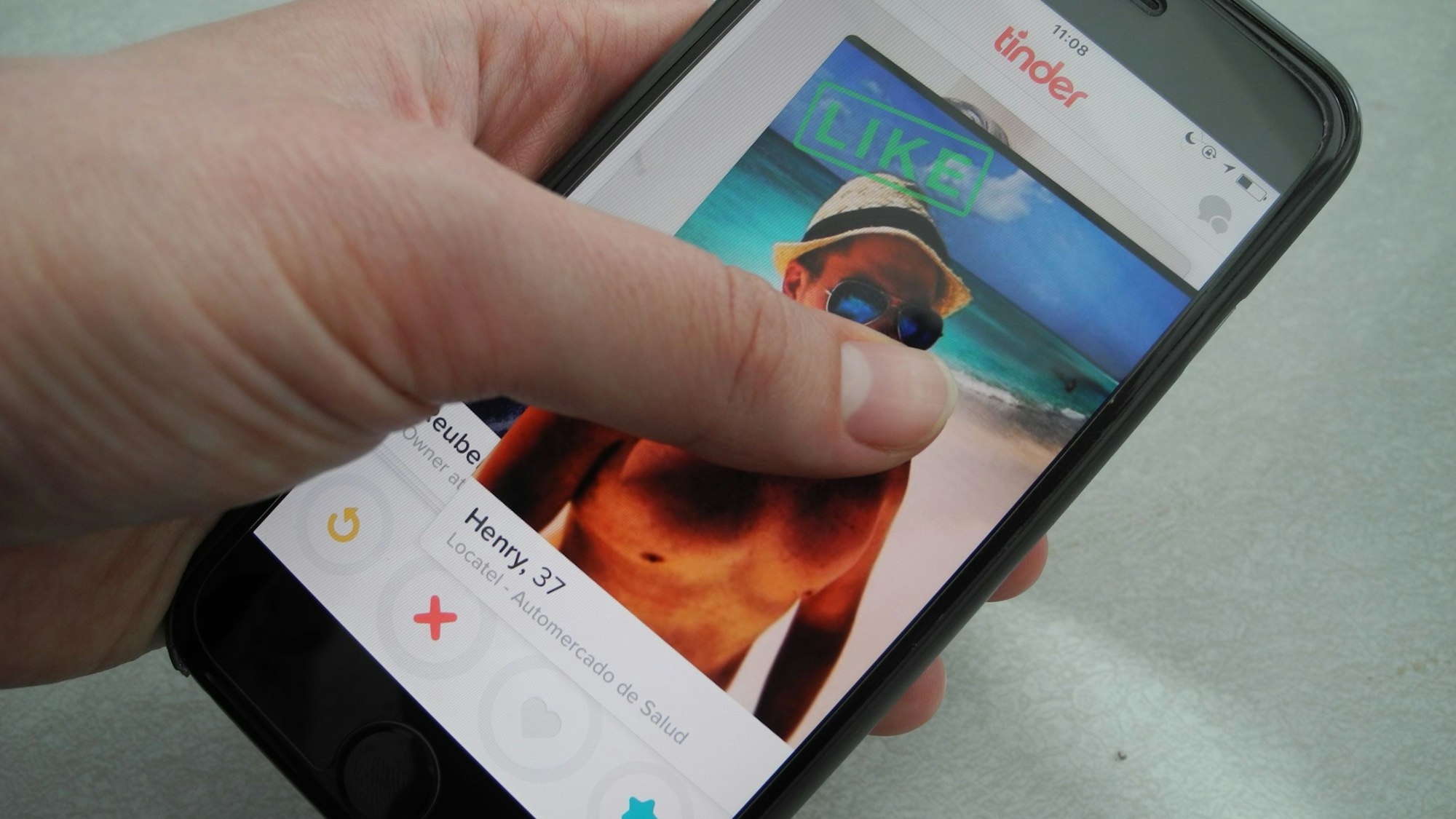 Ein Nutzer hält am 29.03.2016 in New York (USA) ein Smartphone, auf dem die App "Tinder" läuft, in der Hand.