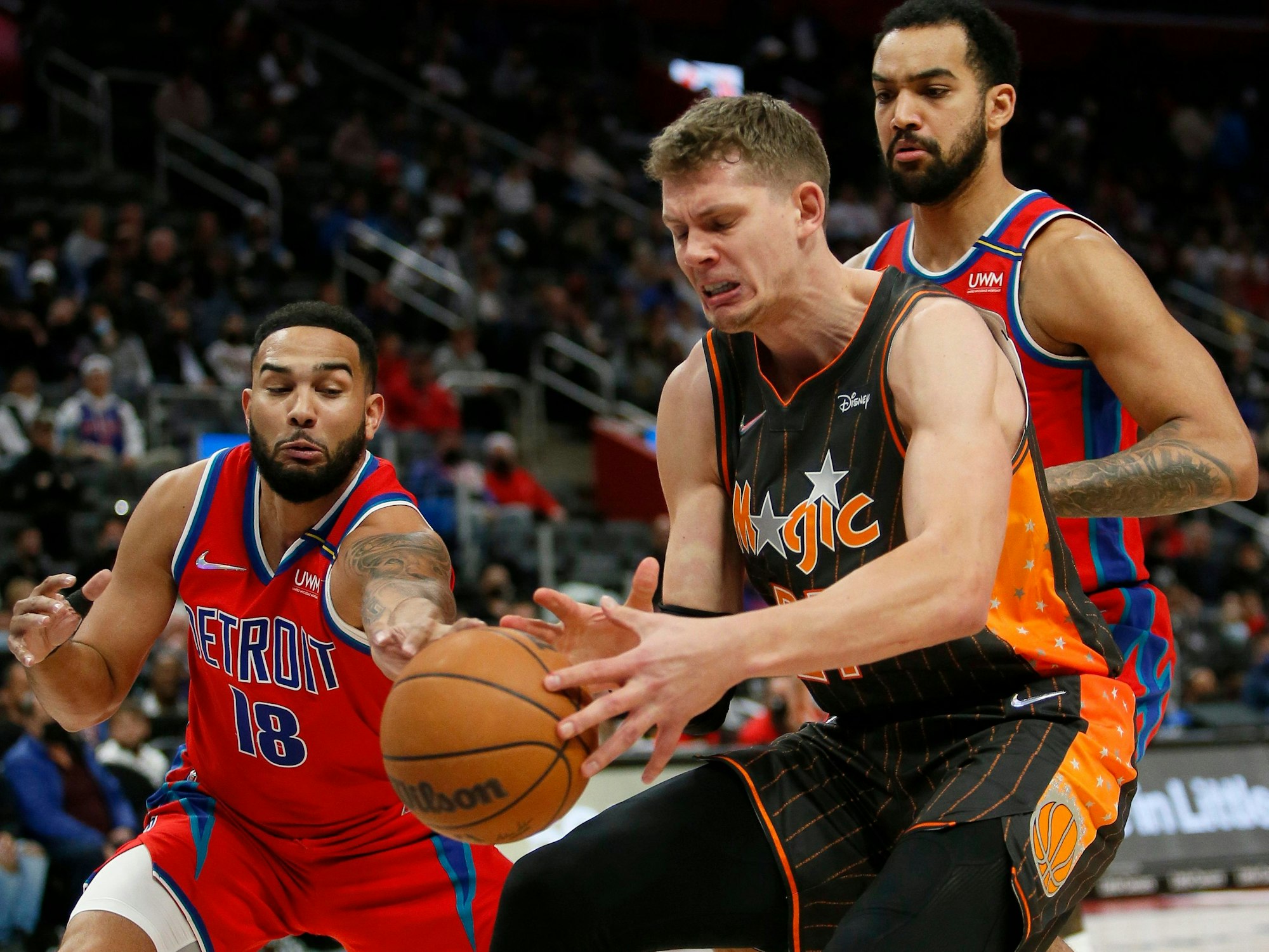 Magic-Center Moritz Wagner (m.) versucht gegen die Detroit-Spieler Cory Joseph (l.) und Joseph Trey Lyles (r.) den Ball zu halten.