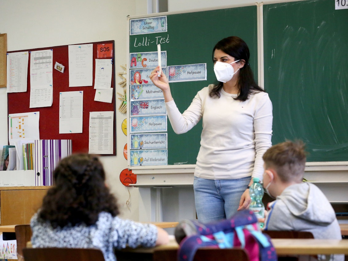 Kamuran Turan, Lehrerin der Klaase 3a der Maria-Kunigunda-Grundschule, erklärt ihren Schülern den "Lolli-Test.