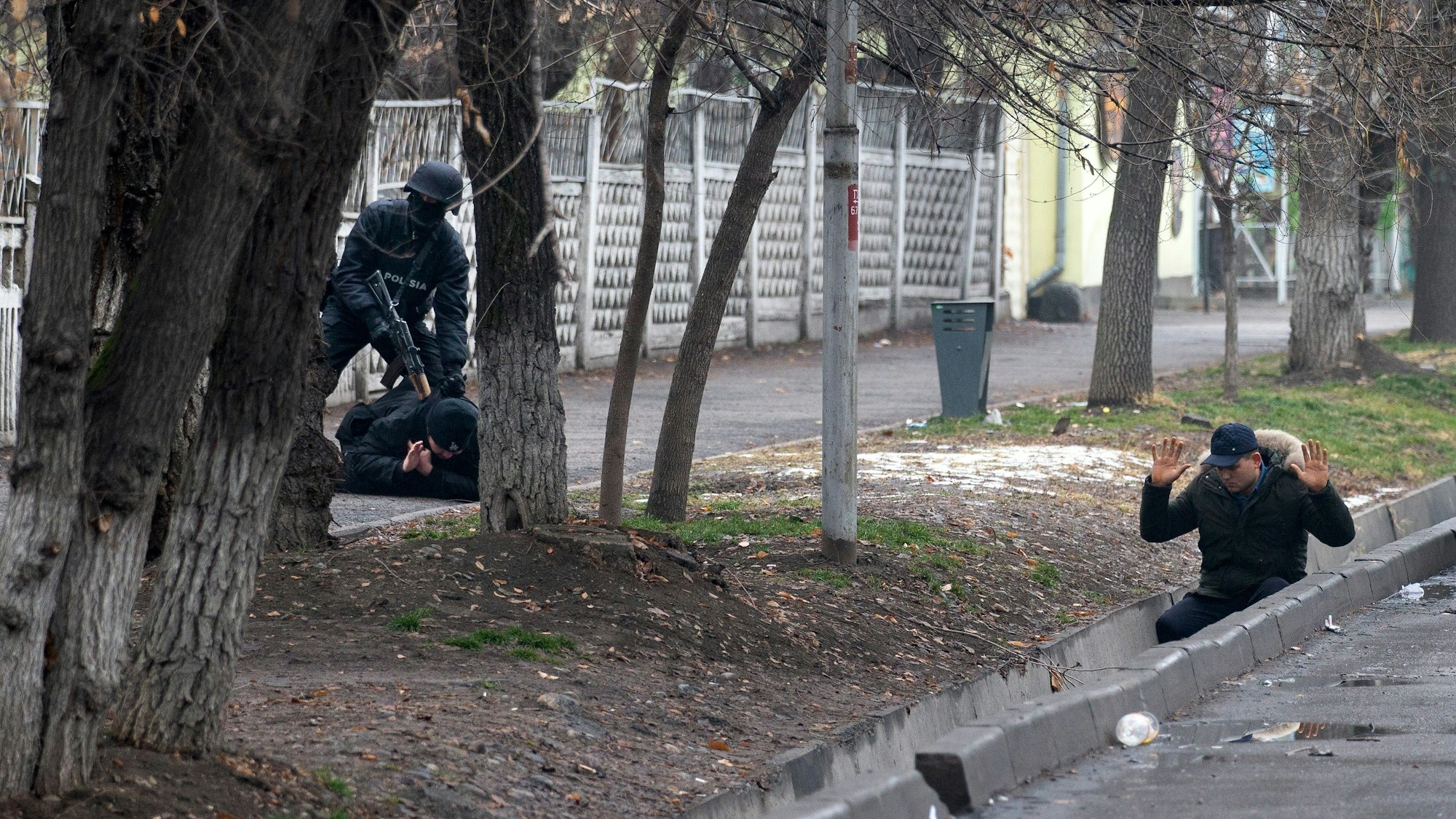 Ein bewaffneter Polizist nimmt am Samstag (8. Januar) zwei Protestanten in Almaty fest. Es seien in Kasachstan mittlerweile fast 6000 Menschen festgenommen worden, darunter viele Ausländer, hieß es. Bei den schweren Unruhen sind offiziellen Angaben zufolge 164 Menschen getötet worden.