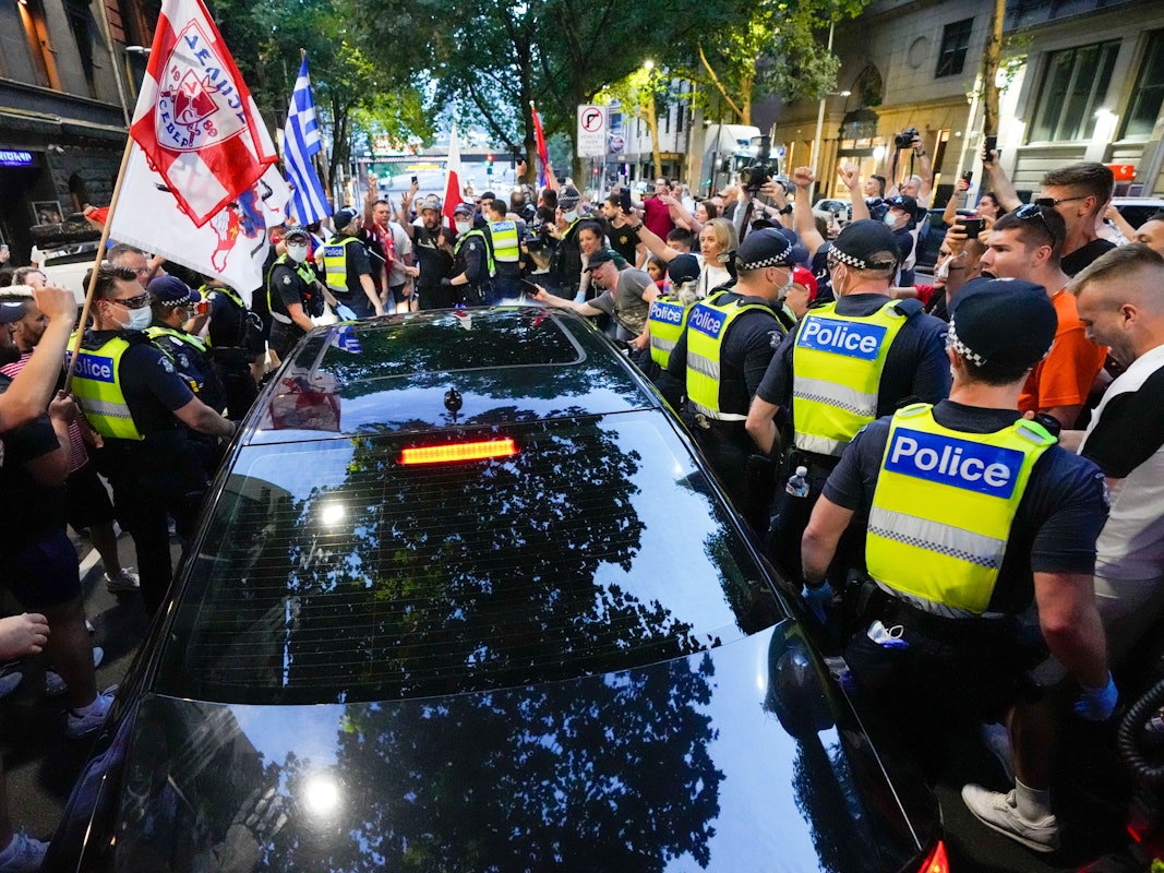 Anhänger des serbischen Tennisspielers Novak Djokovic stehen um ein von der Polizei umringtes Fahrzeug, das das Büro eines Anwalts verlässt.