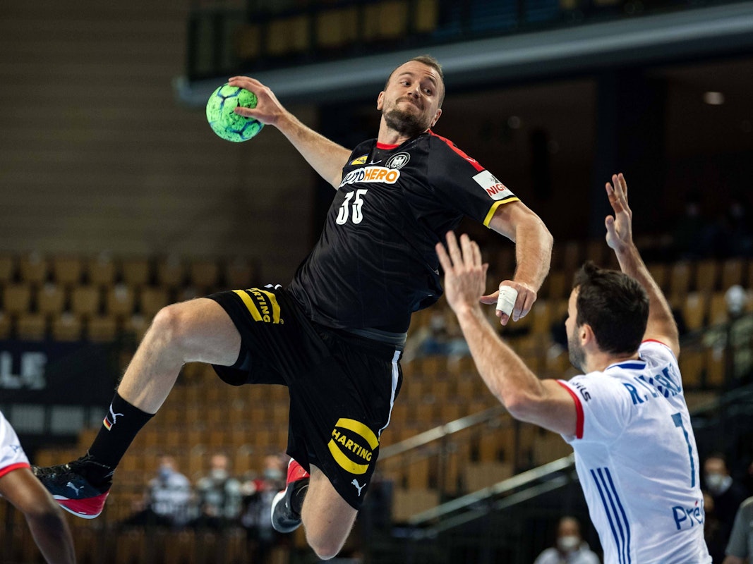 Julius Kühn springt und will den Ball in Richtung des Tores der Franzosen werfen.