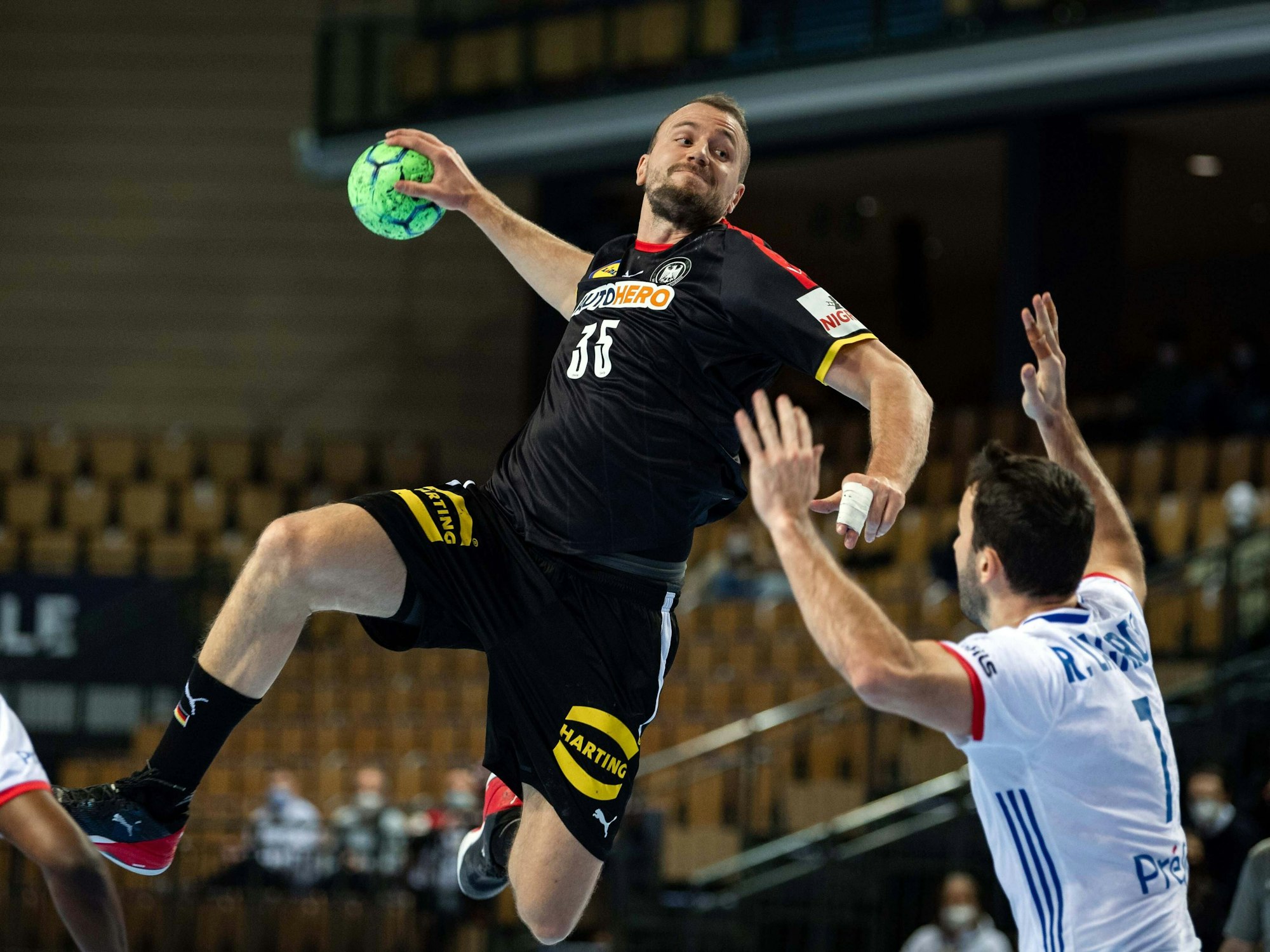 Julius Kühn springt und will den Ball in Richtung des Tores der Franzosen werfen.