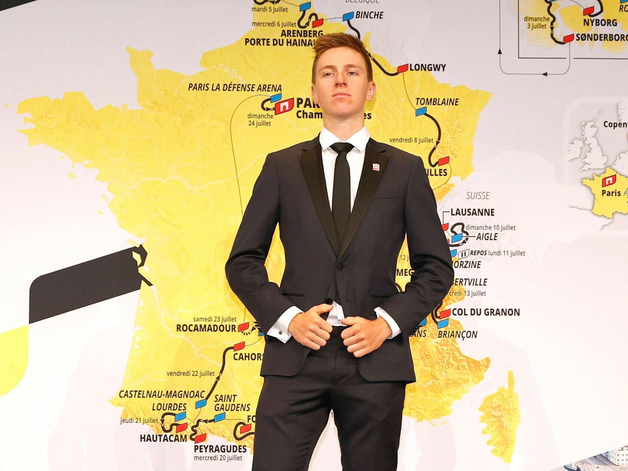 Tadej Pogacar vor einem Plakat mit der neuen Route der Tour de France 2022 in Paris.