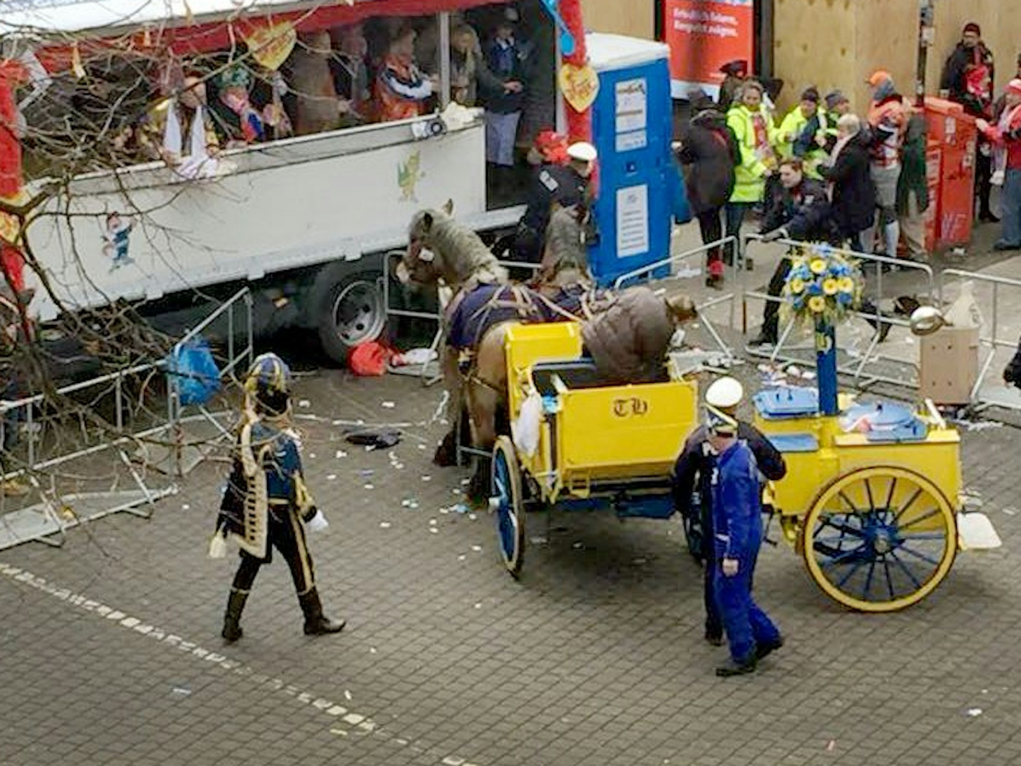 Eine Kutsche mit Pferden steht im Rosenmontagszug vor einem Tribünenwagen.