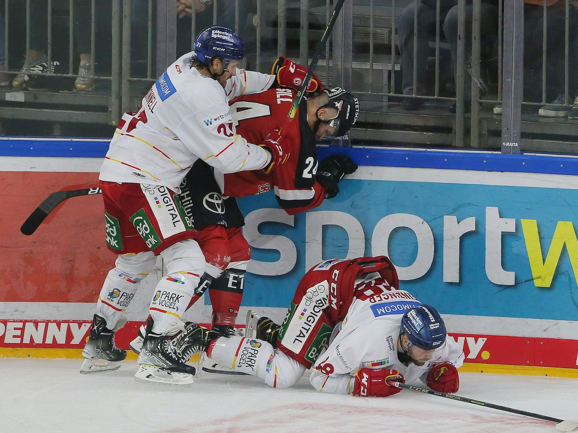 Brendan O'Donnel (DEG), Zachary Sill (KEC) und Niklas Heinzinger (DEG) kämpfen um den Puck.
