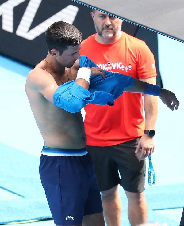Serbe Novak Djokovic wechselt beim Training ein Shirt.