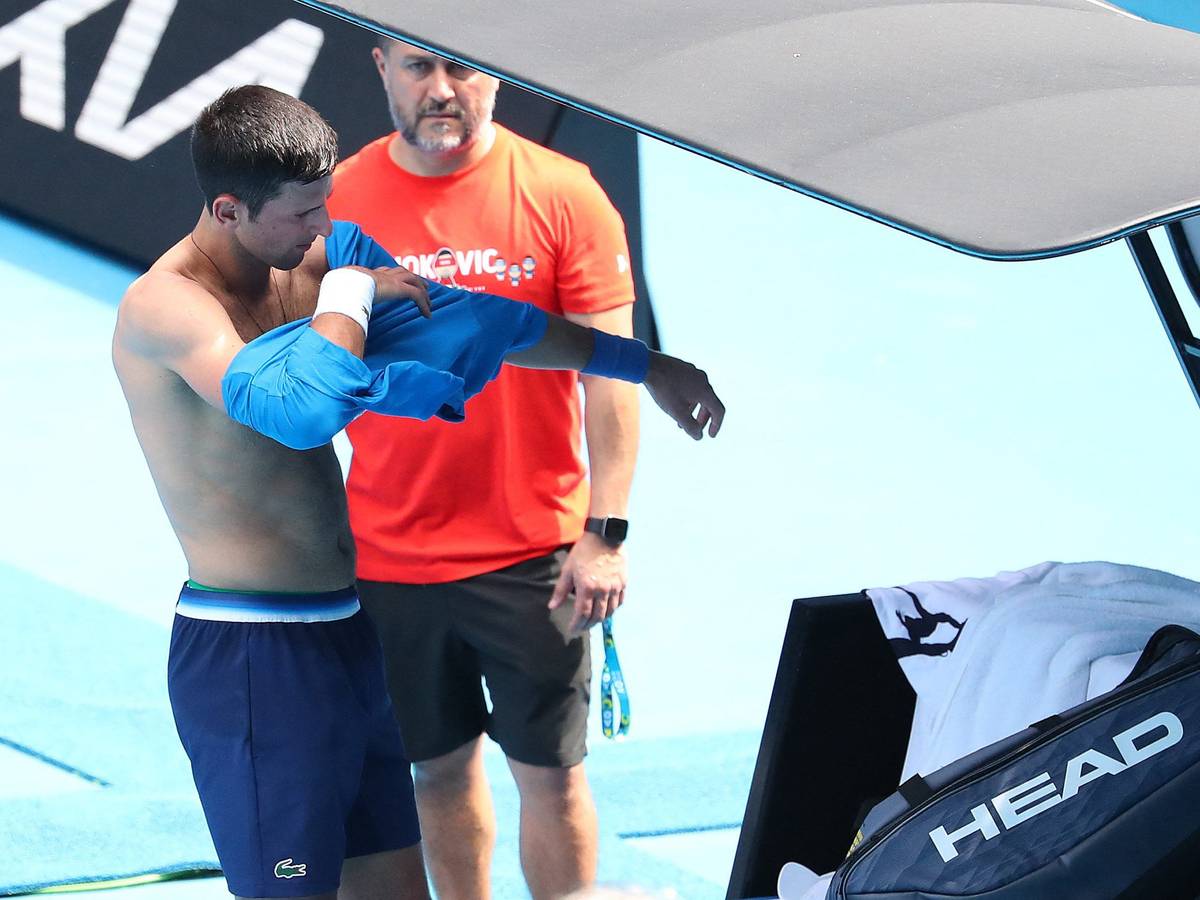 Serbe Novak Djokovic wechselt beim Training ein Shirt.