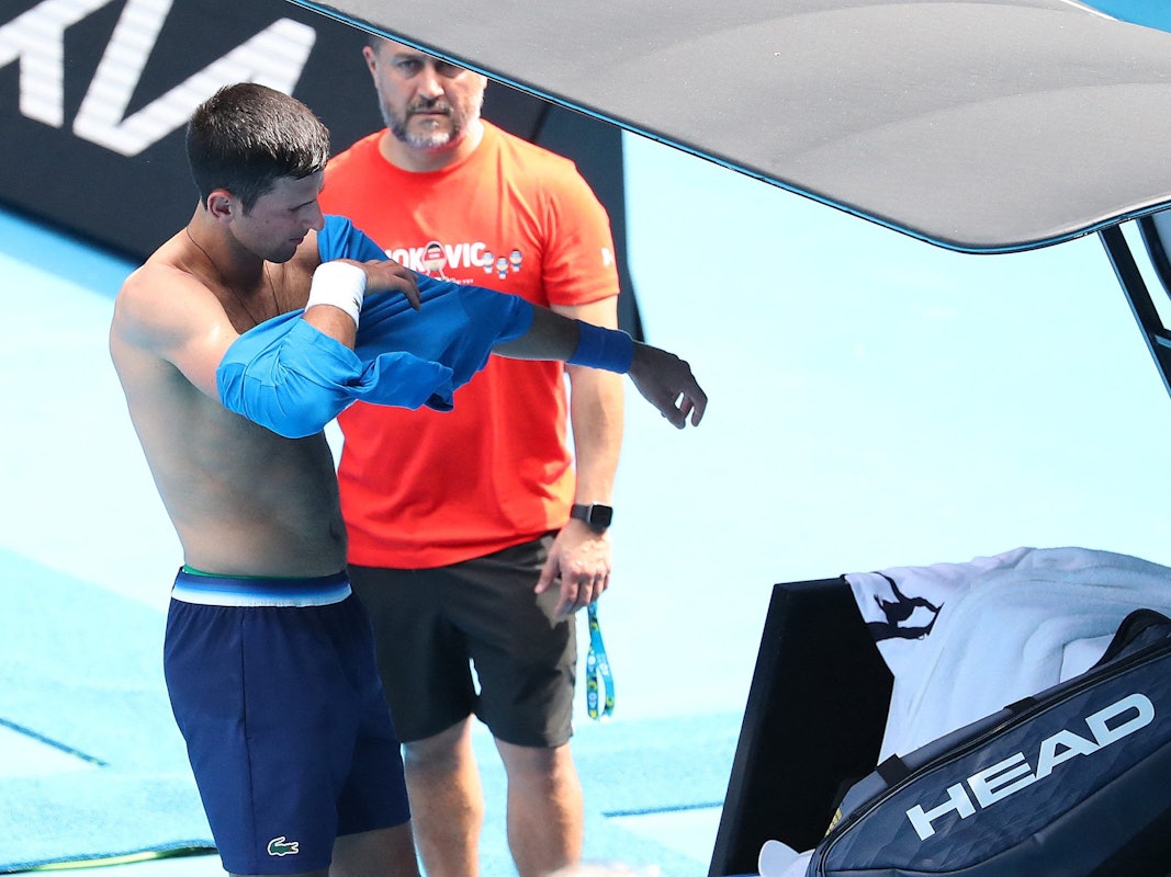Serbe Novak Djokovic wechselt beim Training ein Shirt.