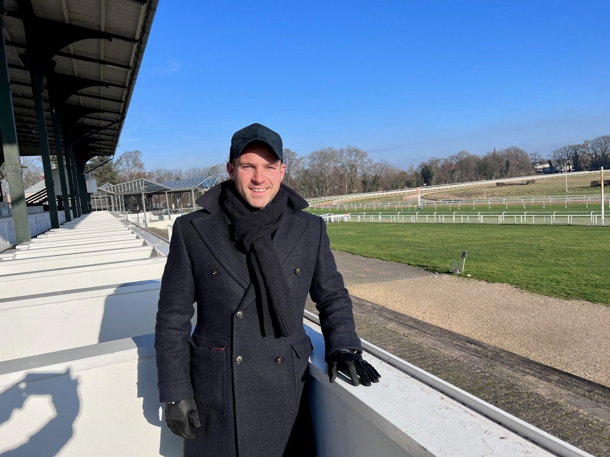 Philipp Hein steht auf der Galopprennbahn.