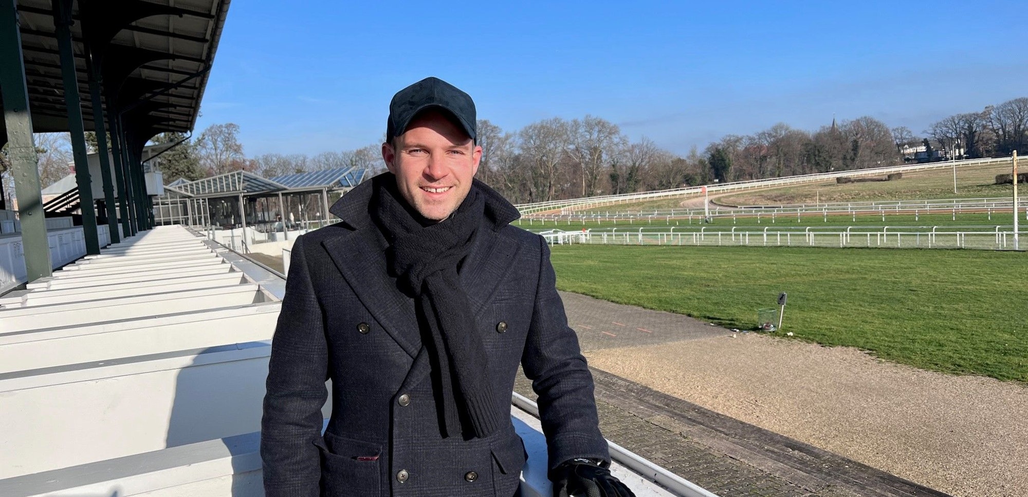 Philipp Hein steht auf der Galopprennbahn.