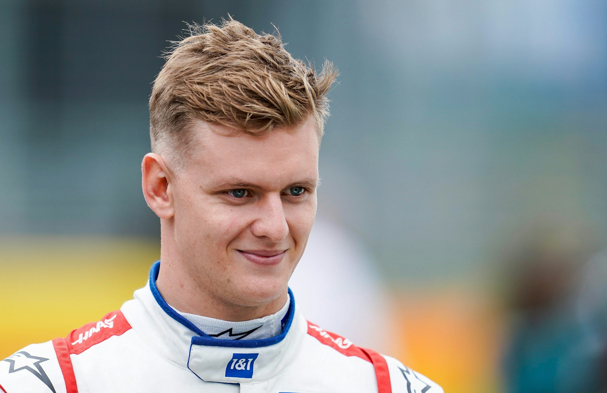 F1-Fahrer Mick Schumacher lächelt.