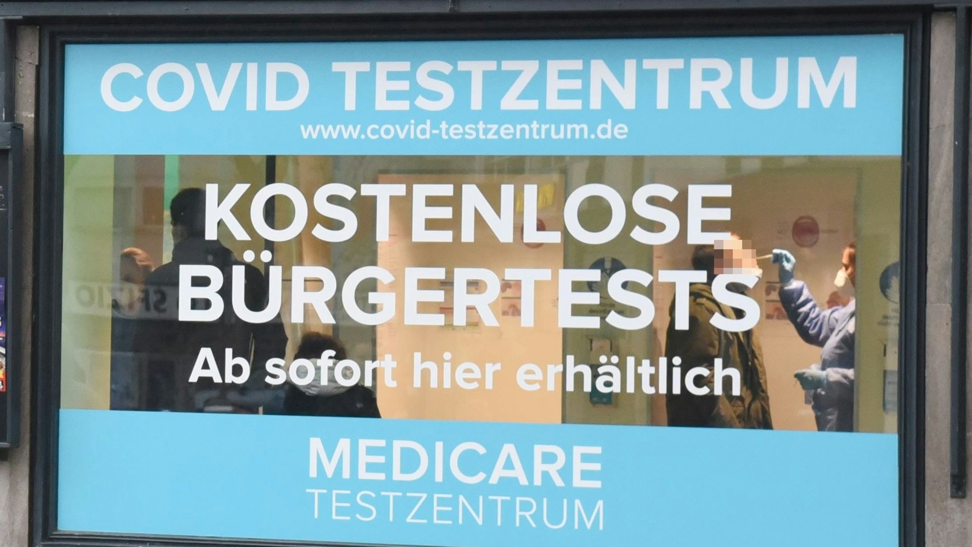 Blick auf das Schaufenster eines Medicare-Testzentrums mit Werbung für den mittlerweile wieder kostenlosen Bürgertest