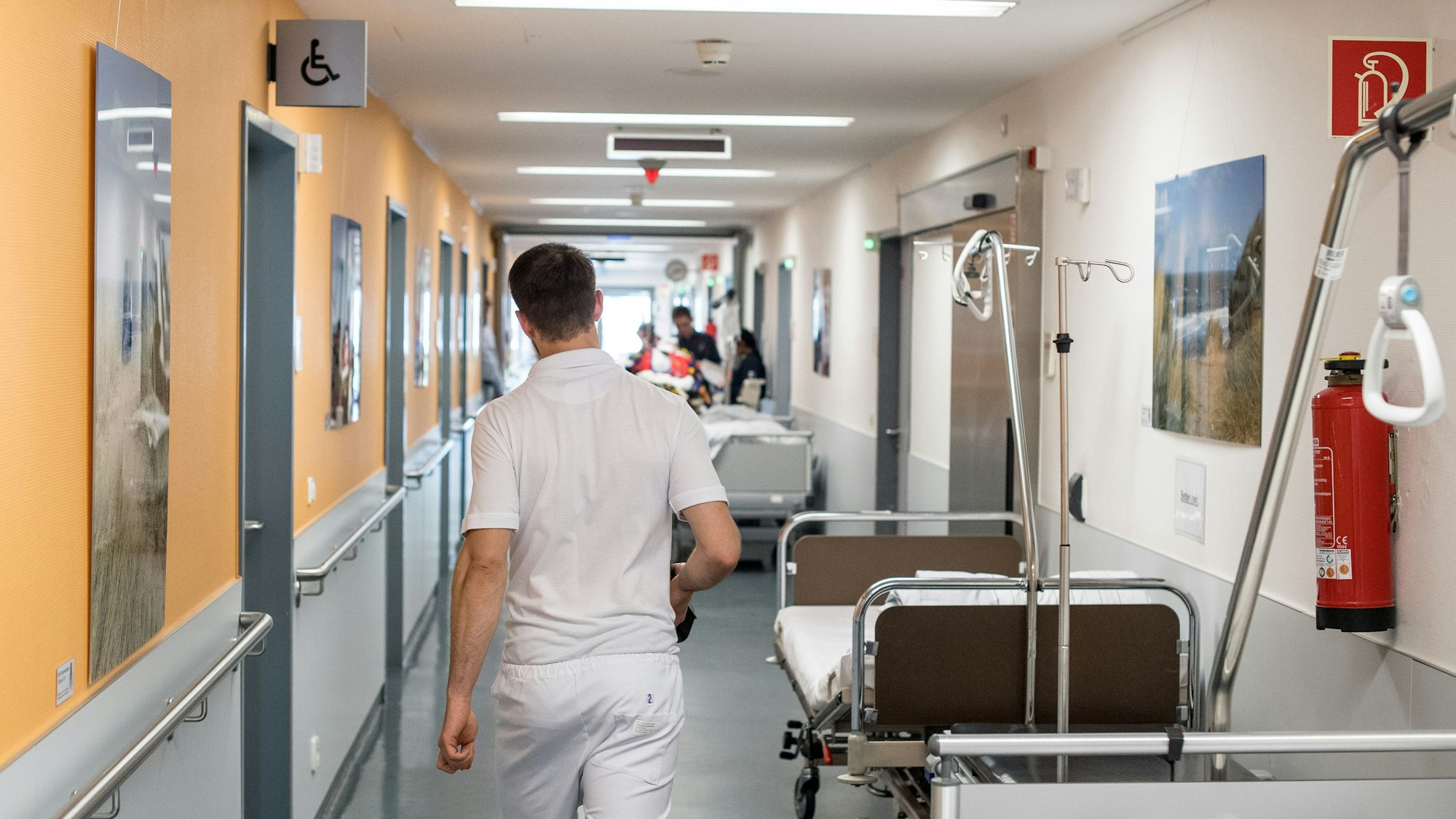 Ein Krankenpfleger geht durch einen Krankenhausflur.