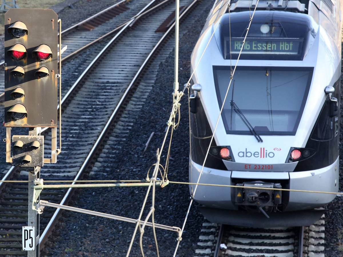 Ein Zug fährt neben einem roten Signal vom Hauptbahnhof ab.