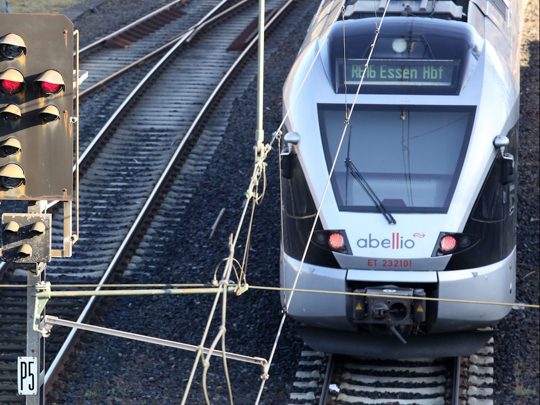 Ein Zug fährt neben einem roten Signal vom Hauptbahnhof ab.