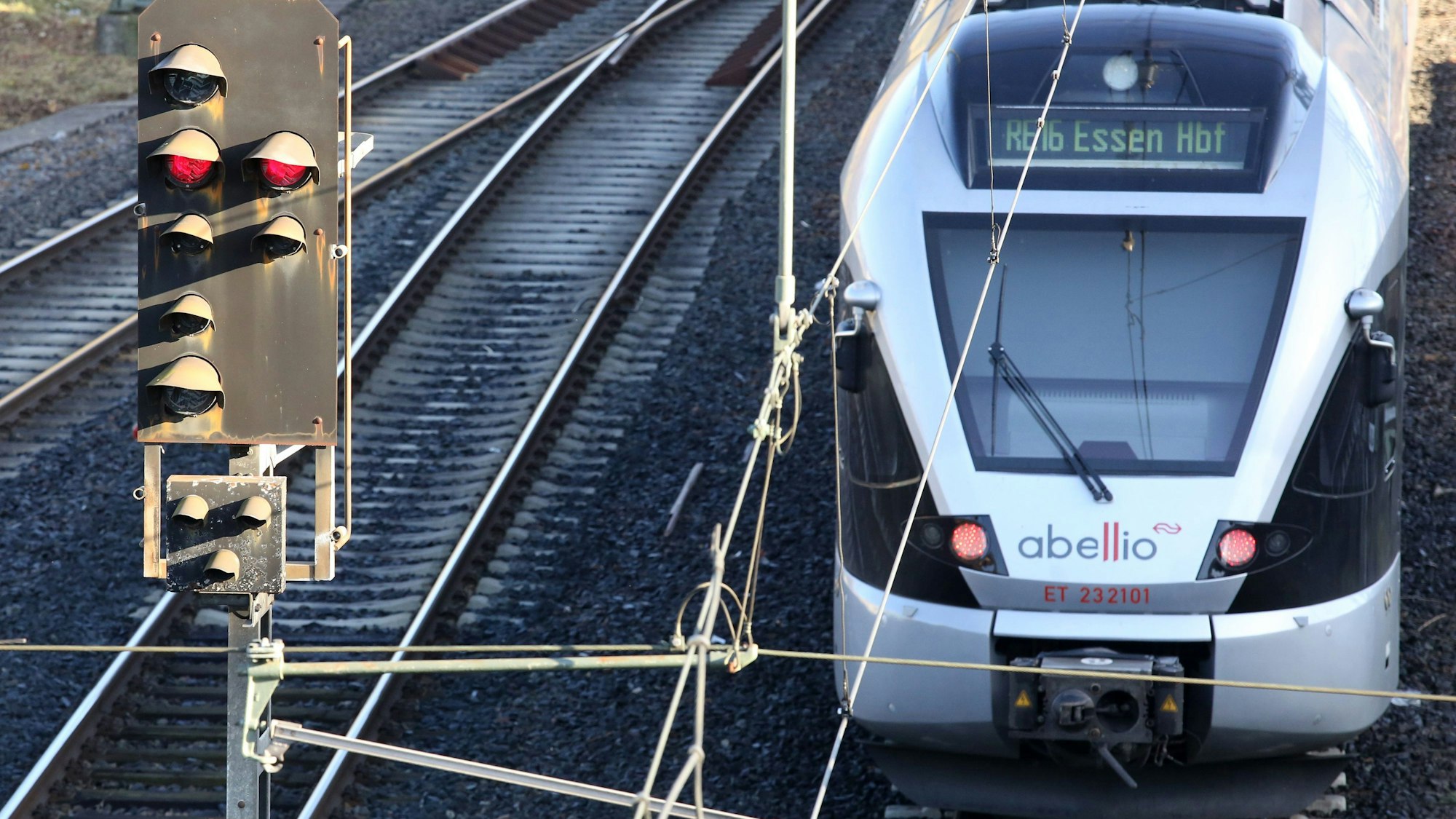 Ein Zug fährt neben einem roten Signal vom Hauptbahnhof ab.
