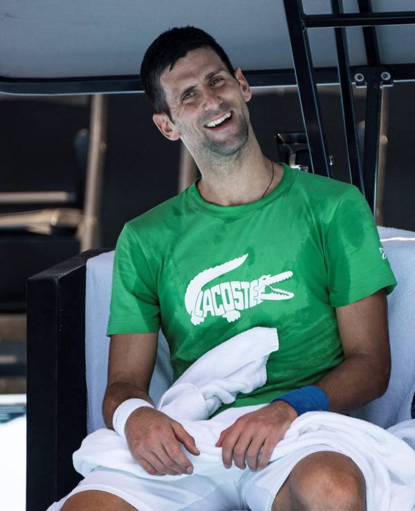 Novak Djokovic lacht während einer Pause im Training in die Kamera.