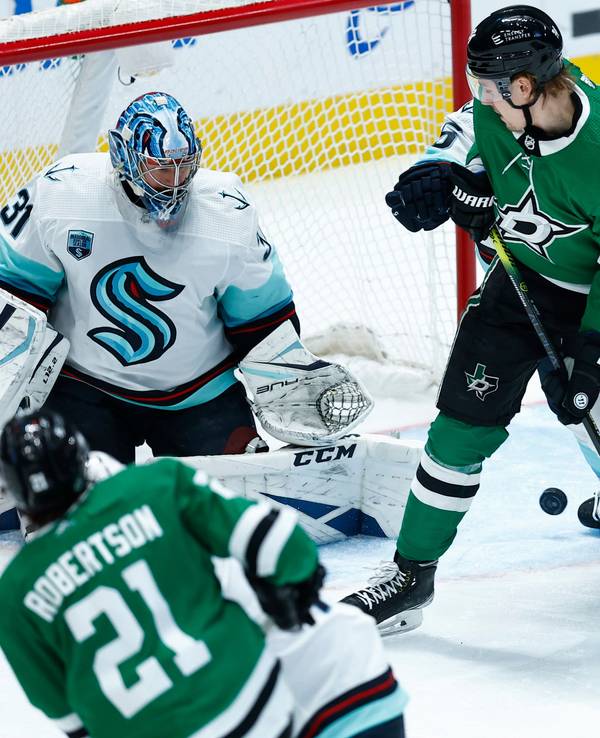 Dallas Stars-Stürmer Roope Hintz (24) lenkt einen Schuss von Stürmer Jason Robertson (21) am Torwart der Seattle Kraken, Philipp Grubauer (31), während des ersten Drittels ab.