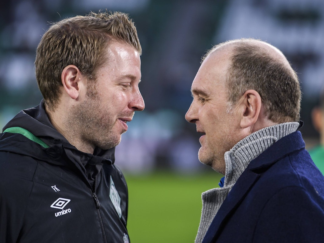 Florian Kohfeldt und Jörg Schmadtke unterhalten sich vor einem Bundesliga-Spiel.