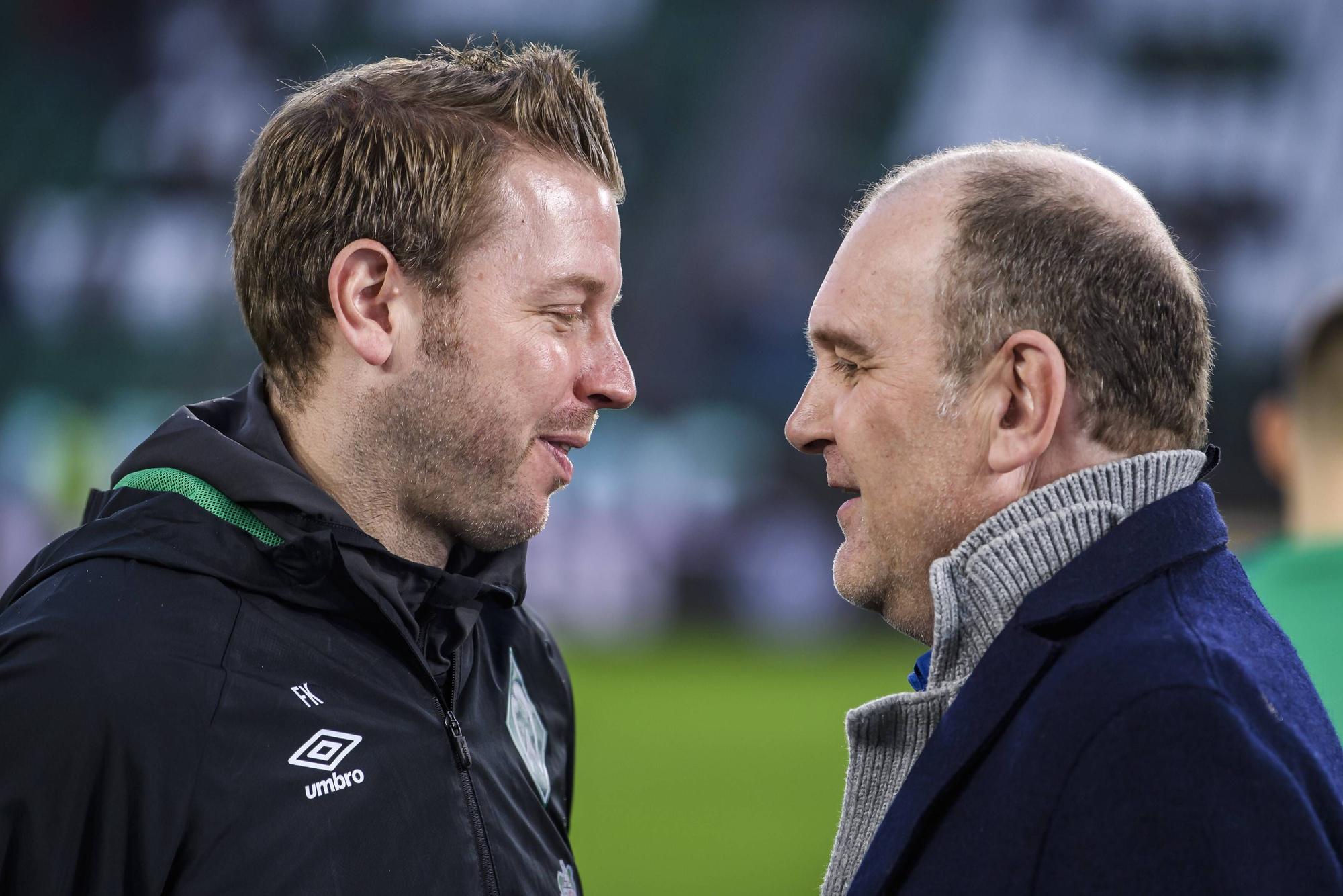 Florian Kohfeldt und Jörg Schmadtke unterhalten sich vor einem Bundesliga-Spiel.