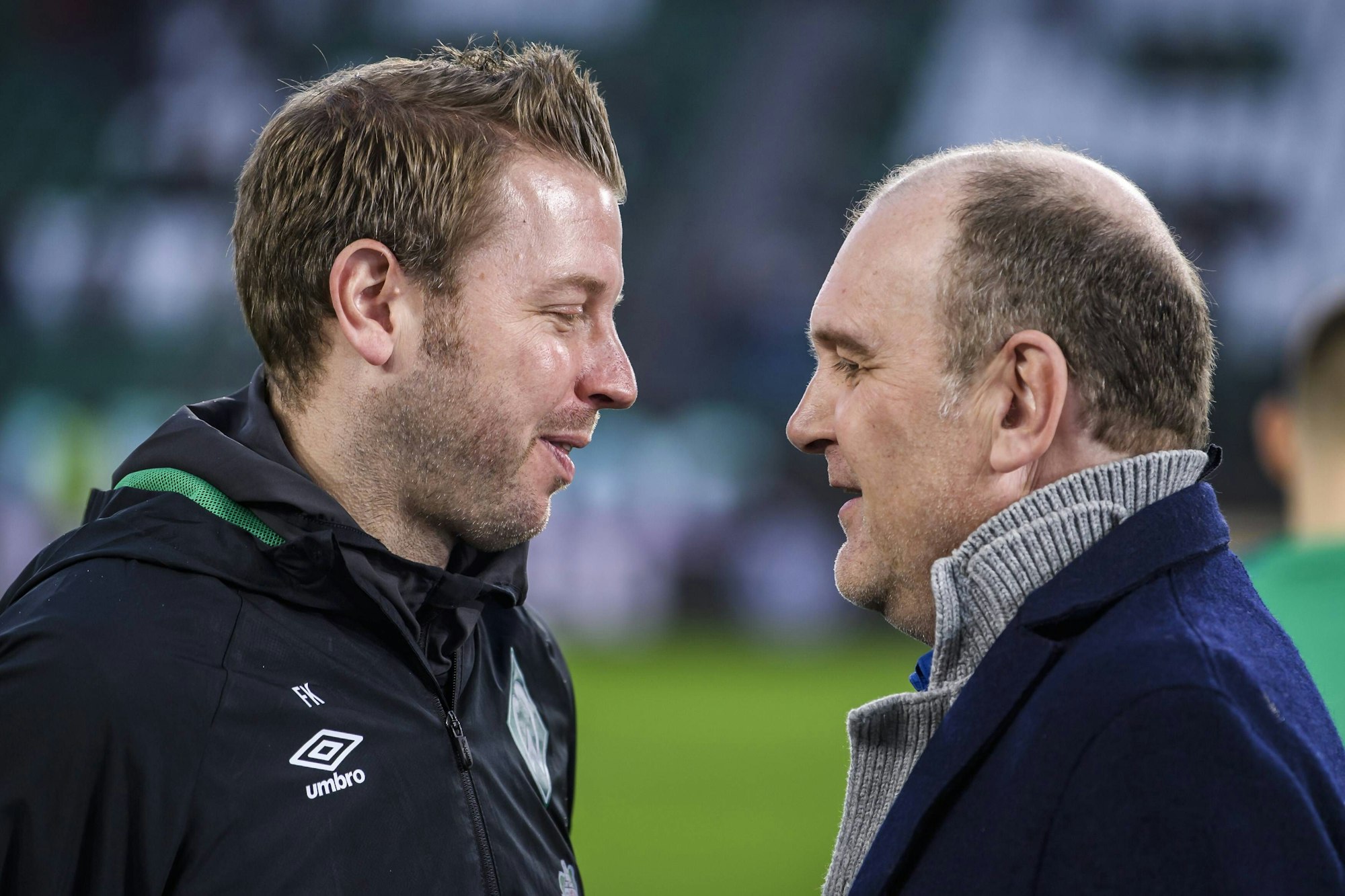 Florian Kohfeldt und Jörg Schmadtke unterhalten sich vor einem Bundesliga-Spiel.