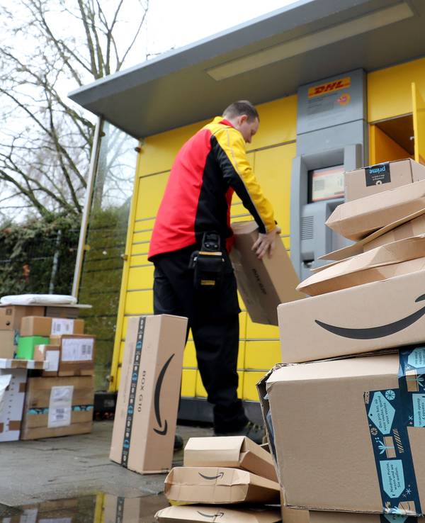 Vor einer Packstation der DHL hat Matthias Peters Paketsendungen aufgestapelt, die er entweder der Station entnommen hat oder aber noch einlegen muss. Das Bild wurde am 22. Dezember 2020 aufgenommen.