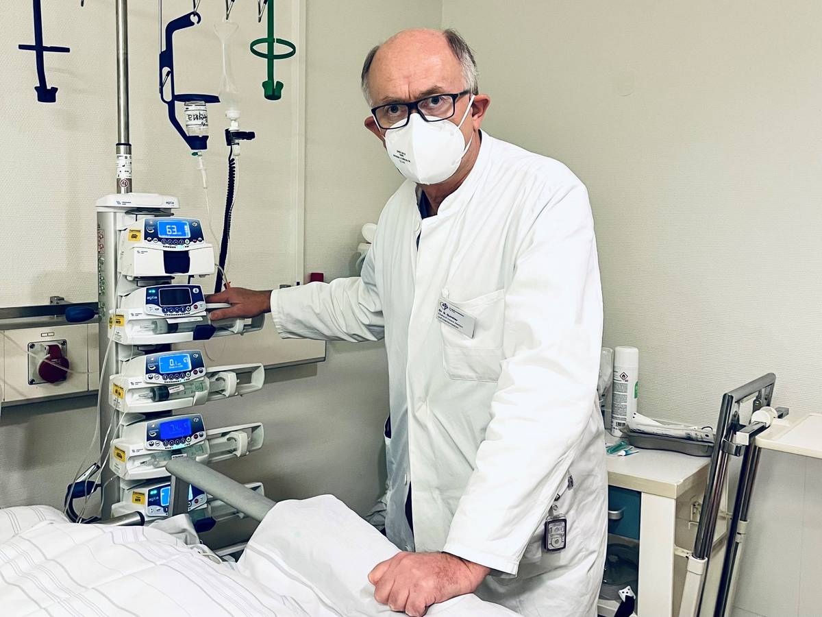 Dr. Gunther Quinkler steht im Krankenhaus an einem Krankenbett.