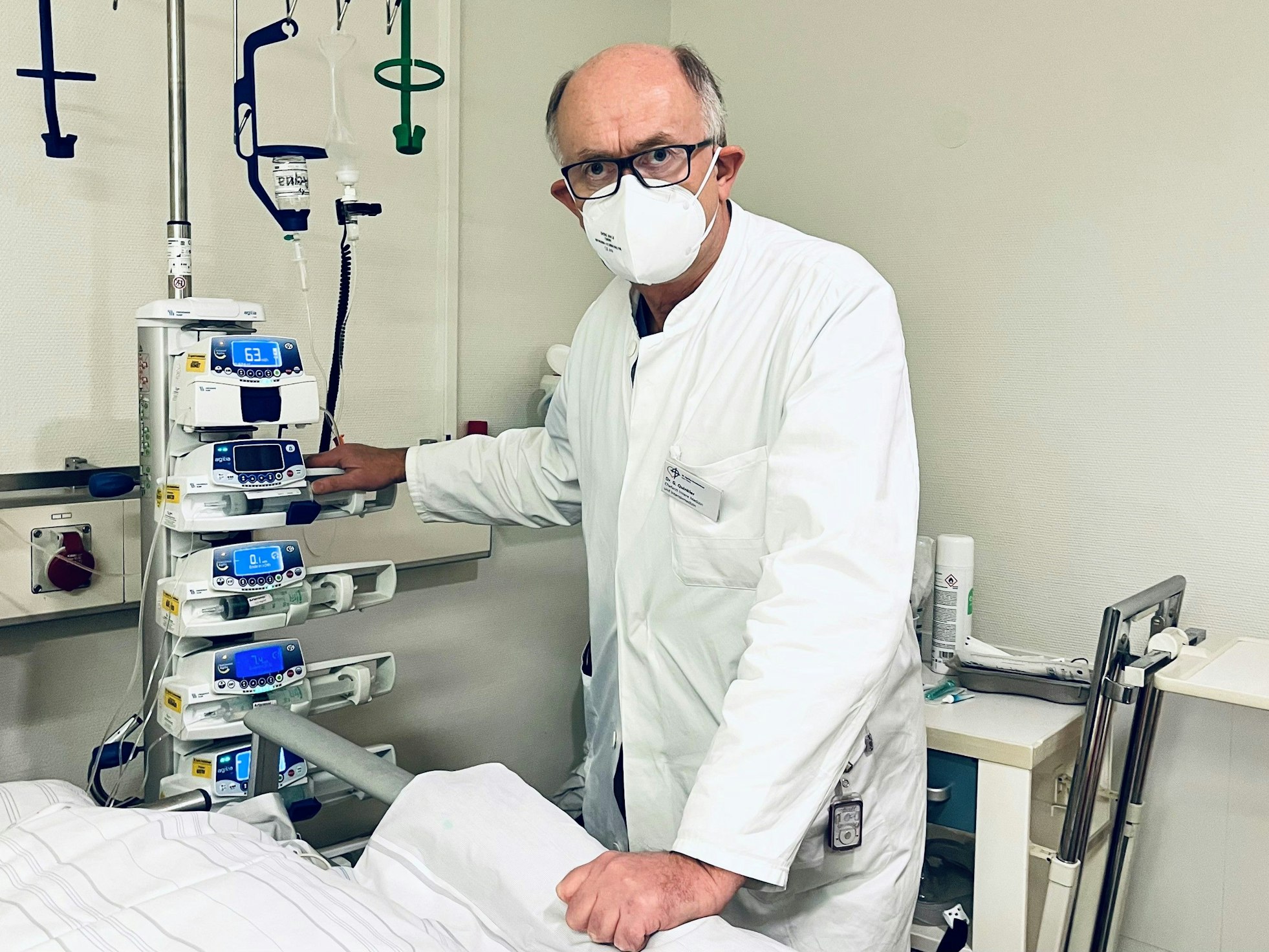 Dr. Gunther Quinkler steht im Krankenhaus an einem Krankenbett.
