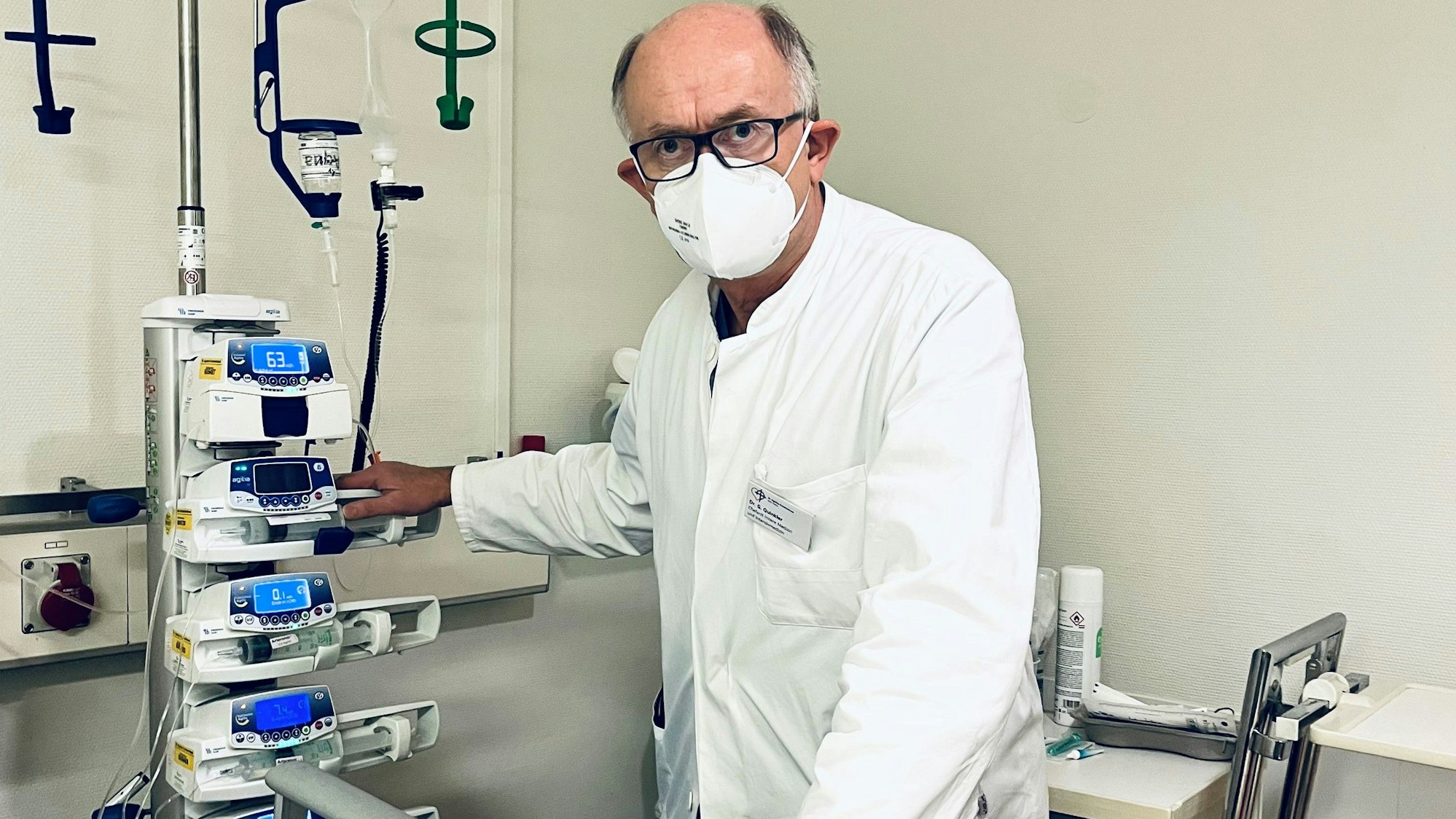 Dr. Gunther Quinkler steht im Krankenhaus an einem Krankenbett.