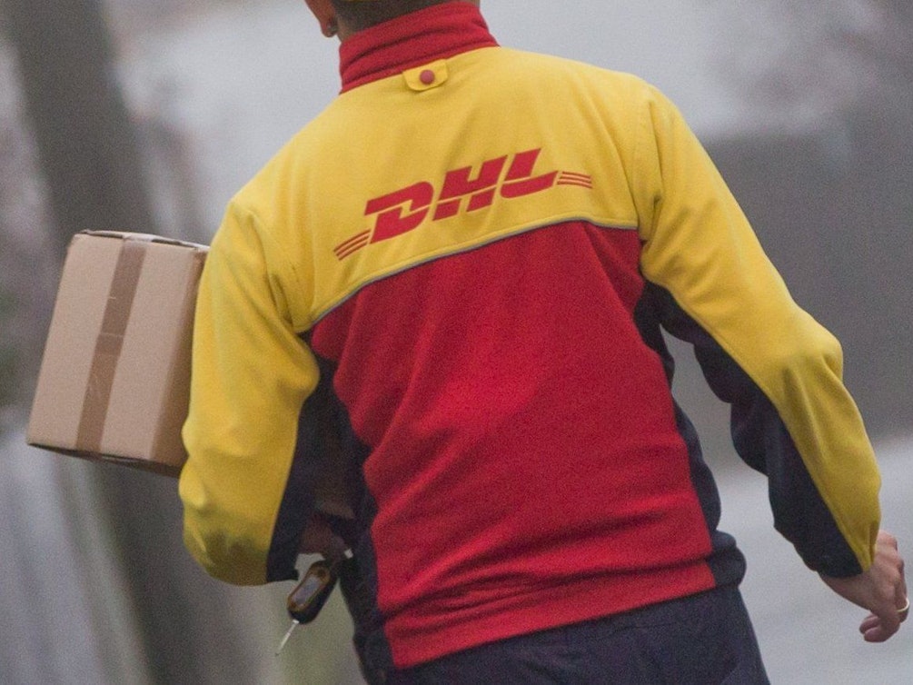 Ein DHL-Paketzusteller liefert am 09.12.2014 in seinem Zustellbezirk in Nürnberg (Bayern) Sendungen aus.