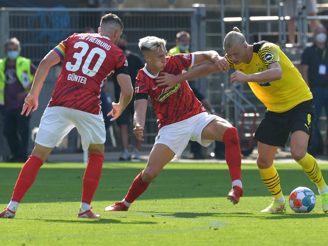 Nico Schlotterbeck (Mitte) am 21. August 2021 im Zweikampf mit Erling Haaland (r.). Christian Günther schaut zu.