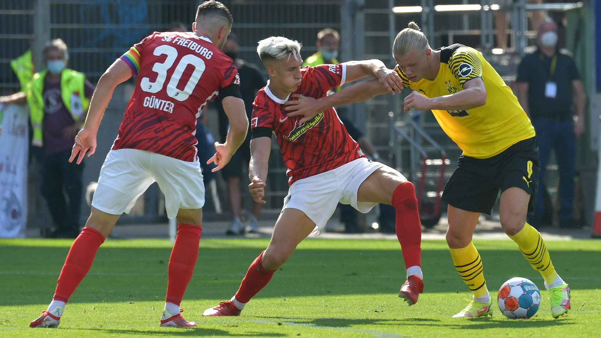 Nico Schlotterbeck (Mitte) am 21. August 2021 im Zweikampf mit Erling Haaland (r.). Christian Günther schaut zu.