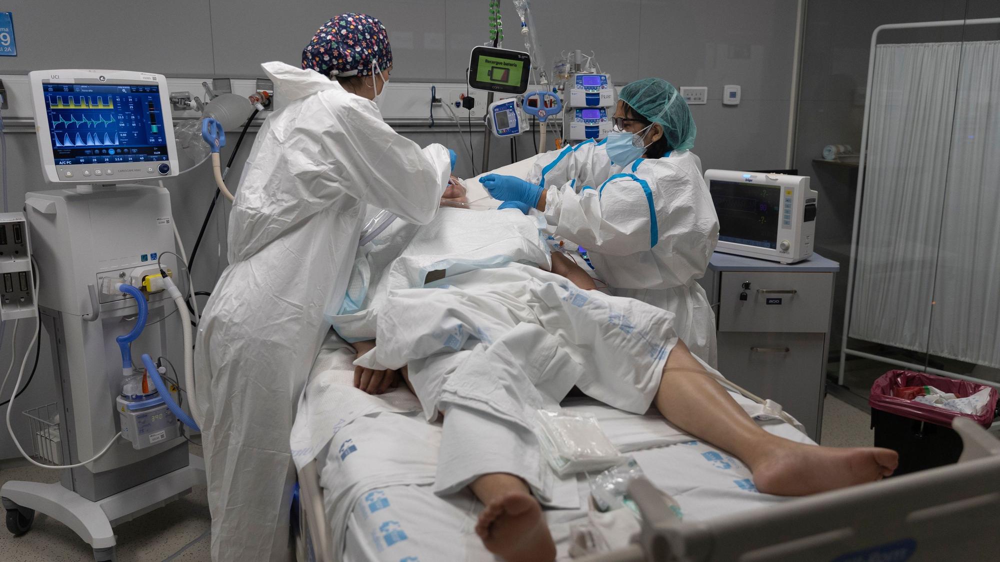 Mitarbeiter des Gesundheitswesens behandeln einen Patienten, der in die Intensivstation des Krankenhauses Isabel Zendal in Madrid eingeliefert wurde.