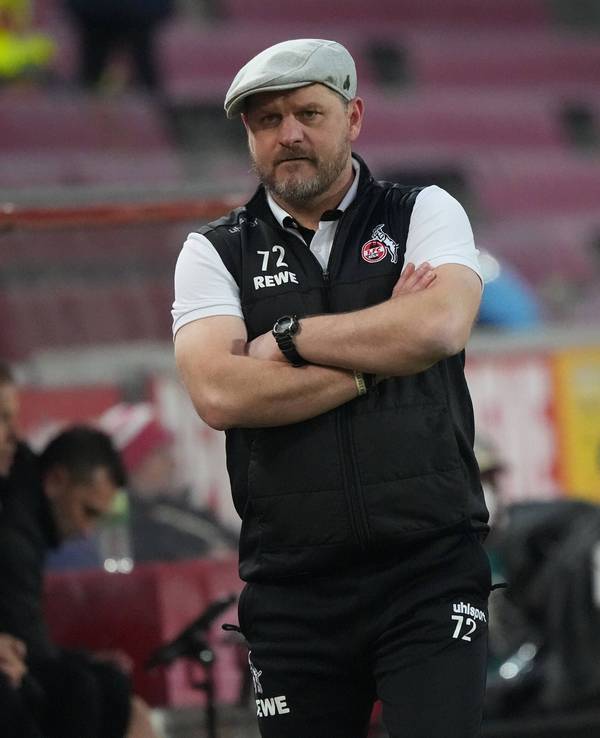 Steffen Baumgart beobachtet mit verschränkten Armen das Spiel seines 1. FC Köln gegen den FC Bayern München.