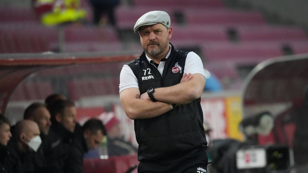 Steffen Baumgart beobachtet mit verschränkten Armen das Spiel seines 1. FC Köln gegen den FC Bayern München.